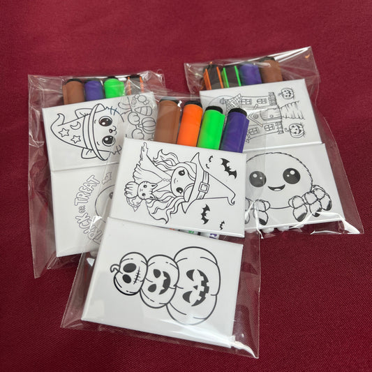 Halloween-themed coloring sheets and markers on a red surface